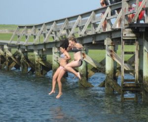 Kate Towey, 15, and Hannah Fieldings, 15, jump off the Sandwich Boardwalk. 