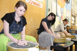 Students in Karyn Phares's art class at the Lawrence School work on the new pottery wheels at the school.