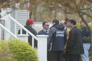 Falmouth police, state police and staff from the Cape & Islands district attorney's office, including First Assistant District Attorney Brian Glenny (in District Attorney jacket), gather in front of the garage where Shirley Reine was killed on the day she was found. Glenny tried the case for the district attorney's office.