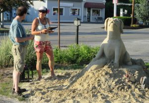 Lee Boisvert, owner of Riverview Bait and Tackle, talks with sand sculptor Morgan Rudluff about her rendering of his dog, Lily. "It looks like my dog," he said. 