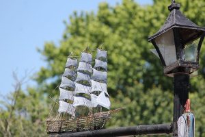 A clipper ship made by Clarence Kacergis decorates a lamp post at the family home across the street from the shop.
