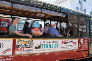 Tourists take a trolley ride down Commercial Street.