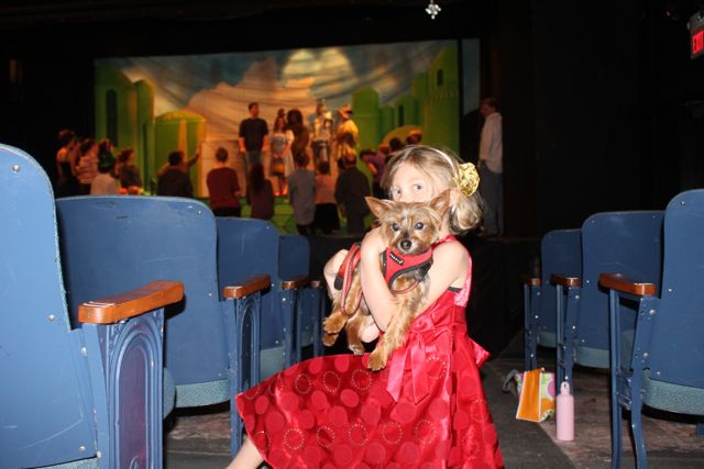 Charlotte Hansen, who plays a munchkin in the Falmouth Theatre Guild's production of "The Wizard of Oz," cradles Toto, who plays Toto.