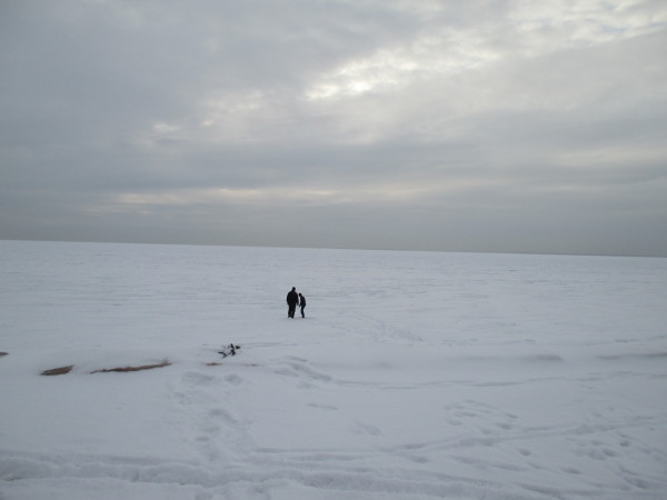 John Furnari and his son, Johnny, walk onto frozen Buzzards Bay, off of Chapoquoit Beach in West Falmouth.