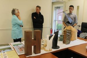 Clare O'Connor, who heads up the Creative Placemaking project for the Cape Cod Chamber of Commerce, talks with Lew French, as Chamber staffer Ben Hughes stands by. In the foreground are models of proposed public art installations.