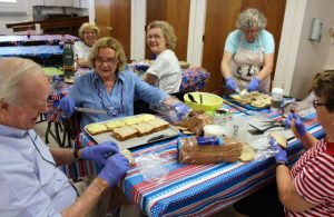 Volunteers prepare sandwiches, among the other foods offered at the annual Strawberry Festival.