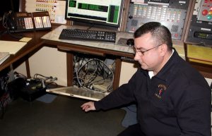 EMS Supervisor Michael Medeiros shows the wiring in the dispatch area.