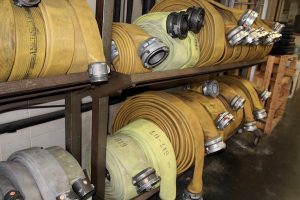 Hoses lined up near the apparatus in the Hyannis Fire Station garage.