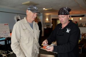 Michael Mullaney, right, of First Line Fishing out of Chatham, admires one of the Fishin Magician lures made by the company run by Steve Bachand, left, of Pocasset. 