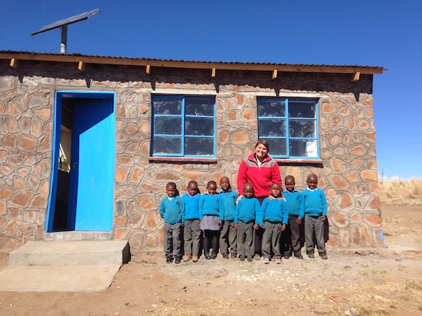 COURTESY KARA HOWARD Peace Corps volunteer Kara Howard stands with her pre-school class in front of the school they helped to build through a grant they submitted.