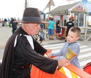 A young boy inquires about Lonergan's unusual outfit. He informs the boy that he is the town crier.